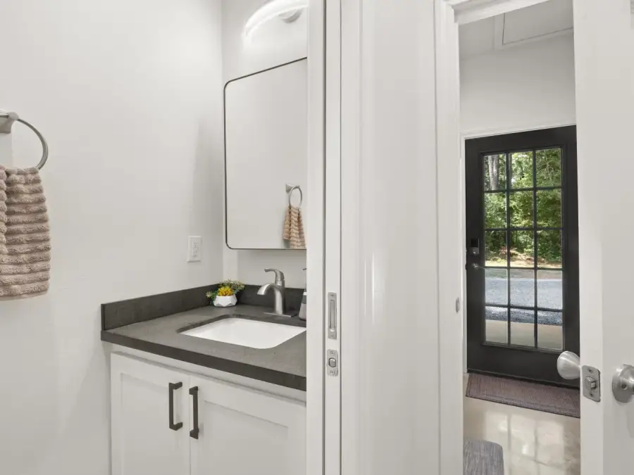 Just past the kitchen is a powder room with a sink and toilet. Just past the kitchen is a powder room with a sink and toilet.